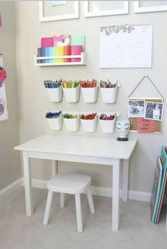 a white table topped with lots of cups filled with crayons