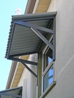 an awning on the side of a building with a window and sky in the background