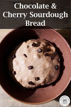 a chocolate and cherry sourdough bread in a brown bowl on a wooden table