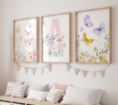 three framed pictures hang on the wall above a wooden bench with pillows and pillow covers