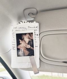 a couple of pictures hanging on the side of a car door window next to a seat belt