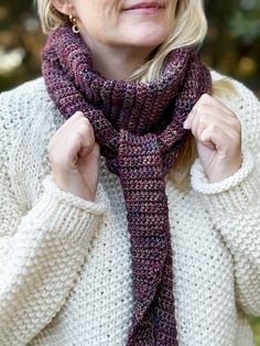 a woman wearing a knitted purple scarf