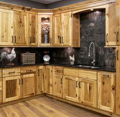 a kitchen with wooden cabinets and black granite counter tops on the wall, along with wood flooring