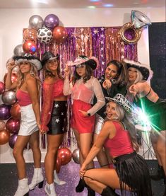 a group of women standing next to each other in front of balloons