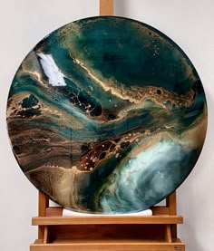 a large plate sitting on top of a wooden easel next to a white wall