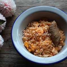 a bowl filled with rice and meat next to flowers