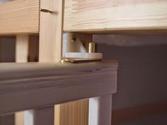 a close up view of a wooden bed frame with the bottom rail partially closed and an electronic lock on it