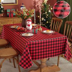 a dining room table set for christmas dinner with red and black checkered tablecloth