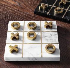 marble tic - tac - toe board with gold rings on it