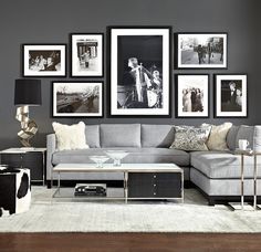 a living room with gray walls and pictures on the wall above the sectional couch,