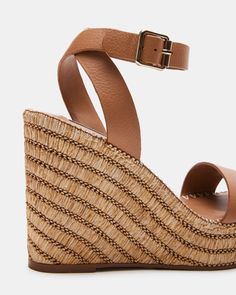 SUNNY + PRETTY + MODERN The CASSIE square toe sandal is set on a platform wedge sole wrapped in woven raffia in diagonal stripes and finished with whipstitching over the top. Square toe platform wedge sandal Crossed ankle straps with buckle closure Woven raffia wrapped platform wedge sole Whipstitch detail around welt 4.25 inch heel height 1.25 inch platform Leather upper material Synthetic lining Synthetic sock Synthetic sole imported Leather Wedge Sandals With Braided Straps For Summer, Leather Wedge Sandals With Braided Straps For Spring, Brown Woven Leather Wedge Sandals For Vacation, Brown Wedge Sandals With Ankle Strap And Woven Sole, Brown Ankle Strap Wedge Sandals With Woven Sole, Chic Brown Straw Wedge Sandals, Summer Brown Woven Leather Wedge Sandals, Brown Straw Wedge Sandals For Summer, Summer Brown Straw Wedge Sandals