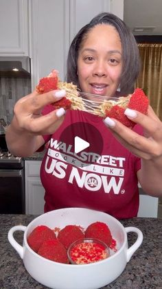 a woman is eating strawberries out of a bowl