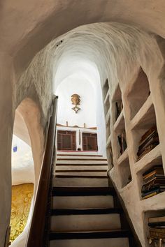 the stairs lead up to an area with bookshelves