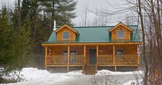 a log cabin in the woods with snow on the ground