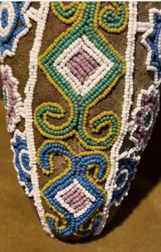 a close up view of a shoe with beaded designs on it's side