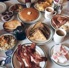 a table topped with plates filled with breakfast foods