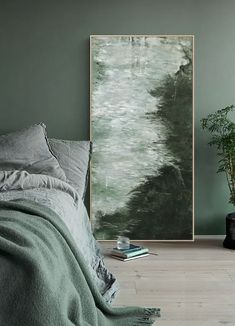 a bedroom with green walls and a large painting on the wall next to a bed