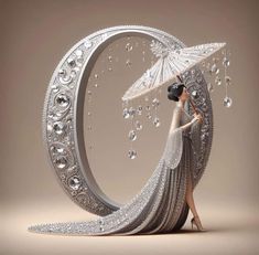 a woman holding an umbrella standing in front of a crescent shaped object with diamonds on it