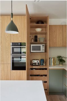 a kitchen with an oven, microwave and cabinets in the corner next to each other