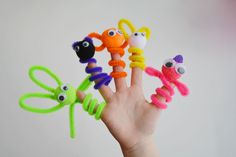 a hand is holding five finger puppets with eyes and hands in the shape of animals