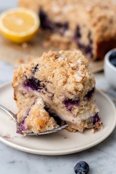 a piece of blueberry crumb cake on a plate with a fork next to it