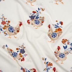 a white fabric with chickens and flowers on it