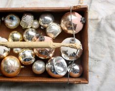 a wooden box filled with lots of shiny ornaments