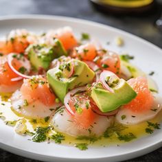 a white plate topped with shrimp and avocado on top of a black table