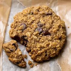 an oatmeal cookie is cut in half on top of brown wax paper