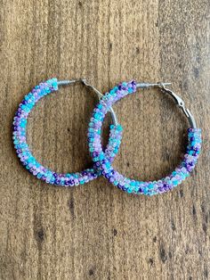 A pair of hoop earrings made with limited edition seed beads in beautiful purple and teal colors! 30mm (1 inch) 40mm (1.5 inch) 50mm (2 inch) These are made from a VERY limited mix so get them while you can! These one of a kind earrings are fantastic for raves, night clubs, parties, summer vacations, festivals or just for a pop of color in your wardrobe.  Made with a spring clasp for ease. Hypoallergenic professional grade metals, none of the cheap stuff used here! Want another size or have some Cheap Stuff, Boho Hoop Earrings, Night Clubs, Purple And Teal, Earring Designs, Summer Vacations, Mermaid Scales, Teal Colors, Jewelry Earrings Hoops