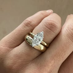 a woman's hand with a gold and white diamond ring on top of her finger