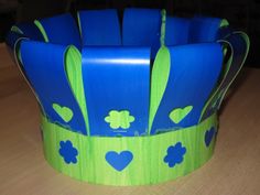 a blue and green flower pot sitting on top of a wooden table