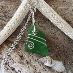 a green sea glass heart and shell on a silver chain with a white bead necklace