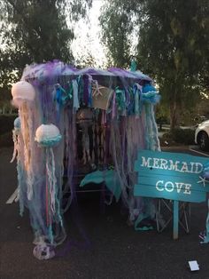 a tent with jellyfish and other decorations on the side of it, next to a sign that says mermaid cove