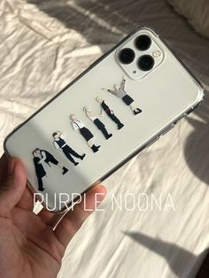 someone is holding up their phone case with the image of four men in suits on it