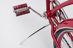 a close up of the handle bars on a red bike against a white background with space for text