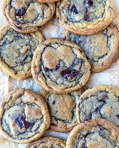 chocolate chip cookies are arranged on wax paper