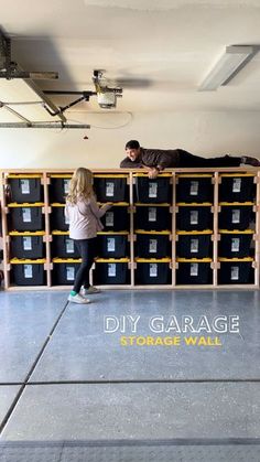 two people standing in front of stacks of storage boxes with the words diy garage on it