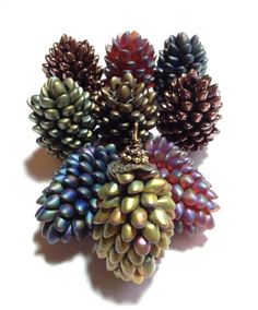 several different colored pine cones on a white surface