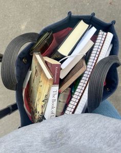 a person is holding a book bag full of books