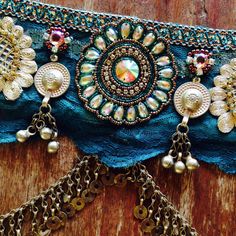 a close up of a piece of cloth with beads and chains attached to it on a wooden surface