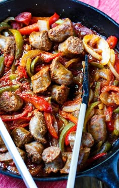 a skillet filled with meat, peppers and onions