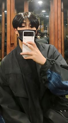 a man taking a selfie in front of a mirror with his cell phone up to his face