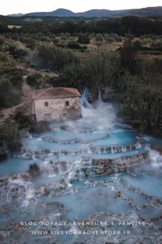 an aerial view of a building in the middle of a river with blue water running through it