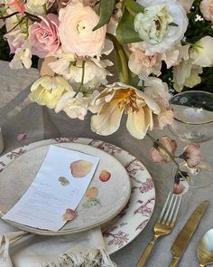 the table is set with flowers and silverware