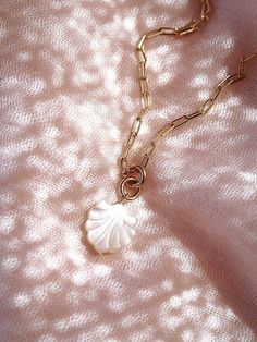 A must have gold chain Seashell Necklace. This tropical shell necklace features an organic carved mother of pearl scallop shell dangling from a gold filled paperclip chain. Complete your beach jewelry collection with this gorgeous everyday piece.✦ DETAILS ✦✧ Name: Kainalu - (ki-NAH-loo) - sea wave.✧ Carved Mother of Pearl Seashell.✧ 18kt gold filled chain with spring clasp.✧ All Ke Aloha Jewelry pieces come packaged thoughtfully, beautifully, and ready for gift giving.✦ This piece features natur Elegant Shell Necklace With Lobster Clasp, Shell-shaped Jewelry With Lobster Clasp, Dainty Shell-shaped Pearl Charm Jewelry, White Shell Dainty Jewelry, Dainty Shell Necklace With Pearl Charm, Dainty White Shell Jewelry, Gold Shell Necklace, Hawaii Necklace, Pearl Seashell