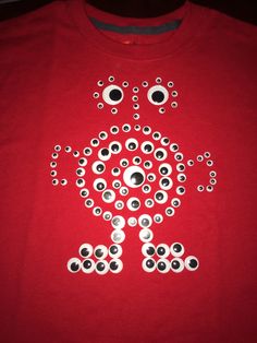 a red t - shirt with black and white buttons in the shape of a turtle