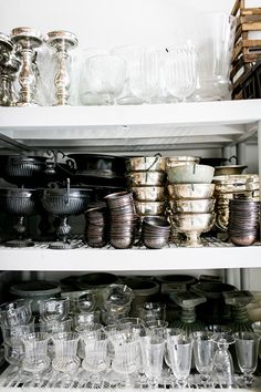 the shelves are filled with many different kinds of dishes and glasses on it's sides