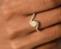 a woman's hand with a ring on it and a white opal in the middle