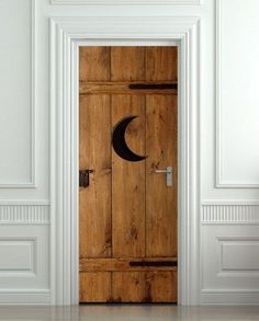 an open door with the moon and crescent symbol on it in a white walled room